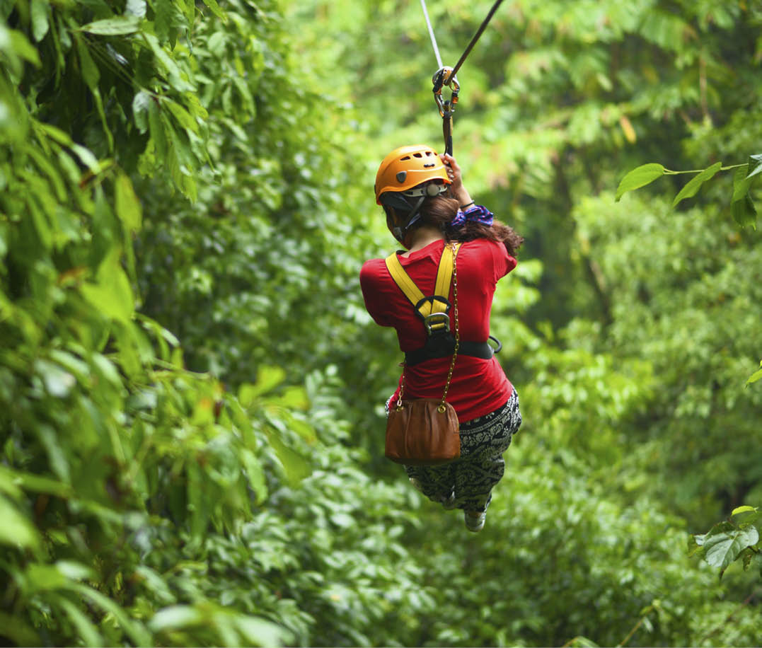 An explorer is moving on cableway in the rainforest