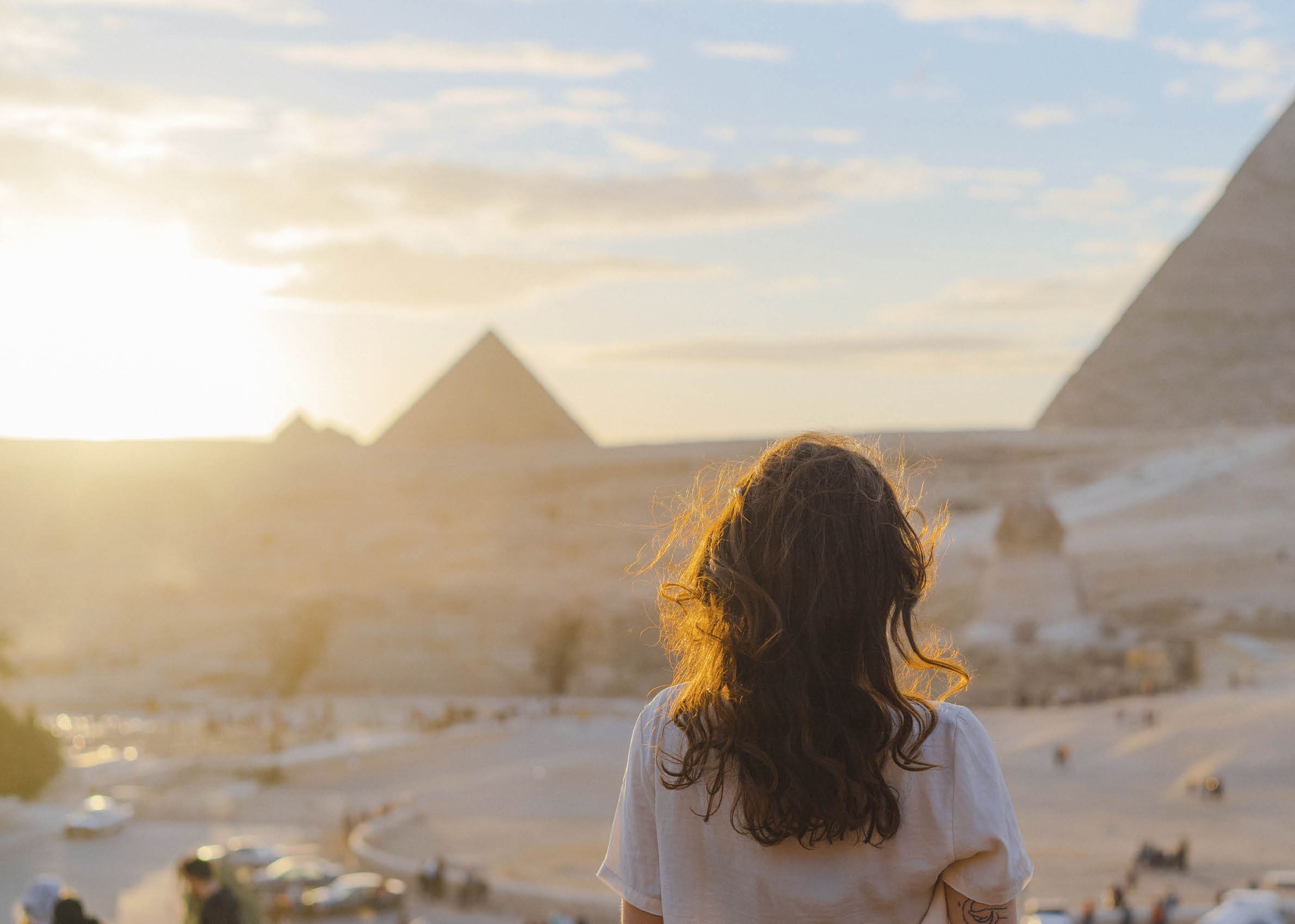 Young Caucasian woman standing on the  terrace on the  background of Giza pyramids
